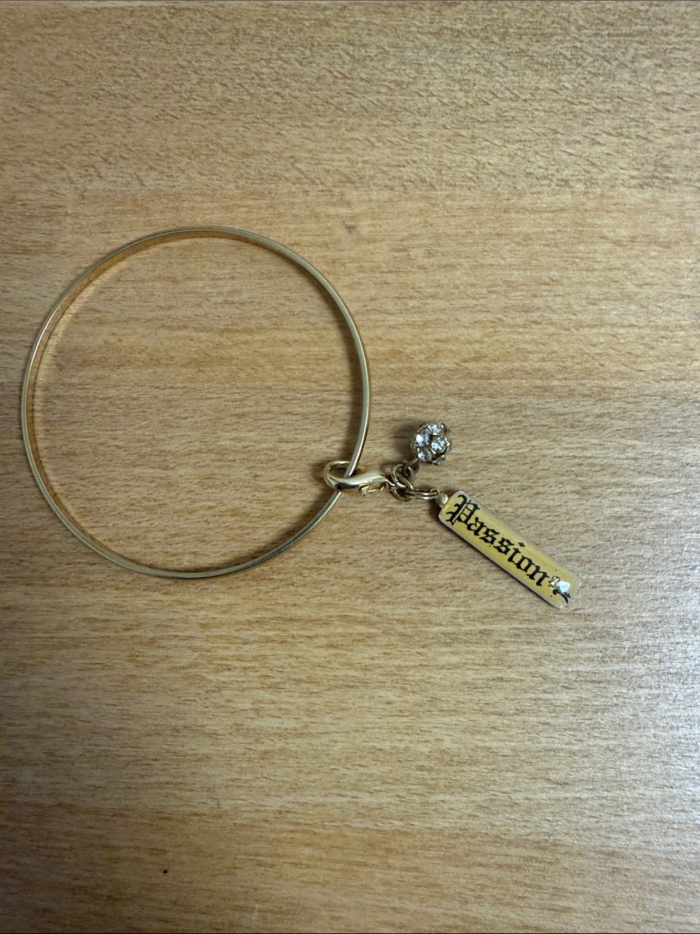 Gold tone circle cuff rigid bracelet with removable passion charm
